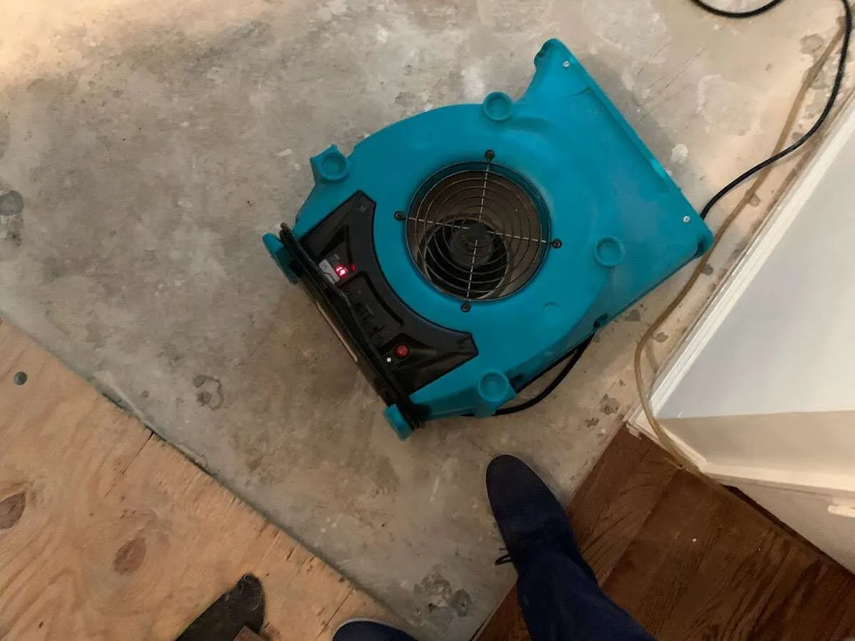 Air mover drying subfloor during Commercial Water Damage Restoration in Newbury